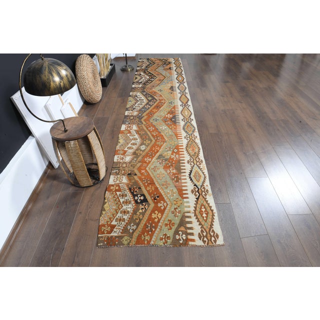 Vintage Hand-Knotted runner rug is a semi-antique vintage area rug. The '70s Eastern region of Anatolia's unique rug is...