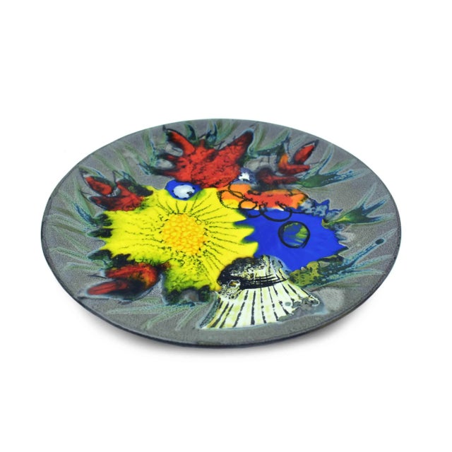 The plate is a stunning example of French mid-century decorative art, perfect for adding a touch of elegance to any room...