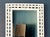 A beautifully detailed vintage white wicker mirror featuring an intricate braided frame and sculptural woven loops. The...