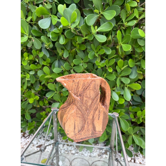 Signed sculptural studio pottery pitcher with an organically formed, asymmetrical shape and richly textured surface. The...