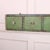 Interesting 19th C English wall hanging pine bank of drawers with old worn paint. 1890 This piece is designed in the style...