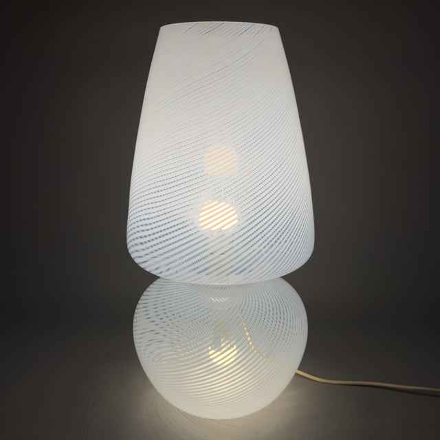 A rare and imposing Murano glass table lamp, produced by the prestigious Fabbian company in the 1970s. This magnificent...