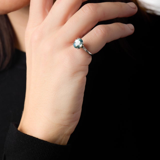 This exceptional vintage ring is defined by the rare beauty of its GIA-certified 4.30 carat teal sapphire, a natural...