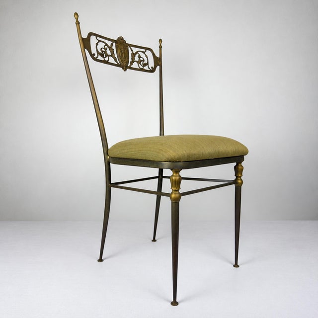 A rare pair of Italian mid-century Chiavari chairs featuring slender brass frames and elaborately decorated backs. The...