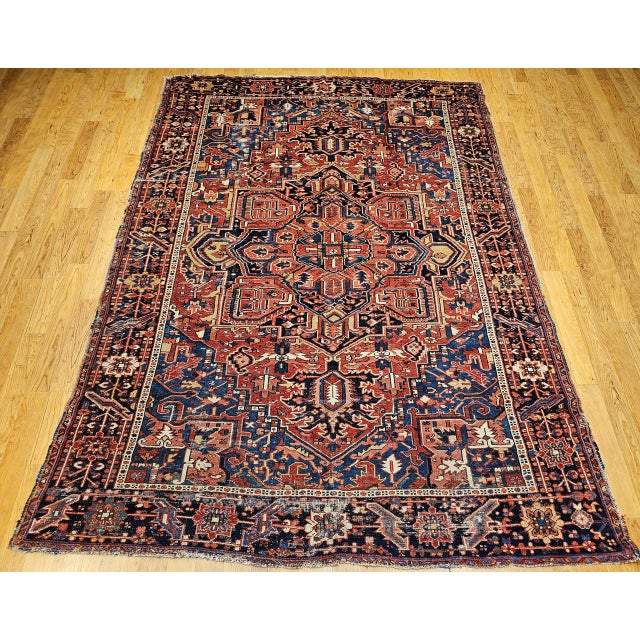 "A magnificent late 19th century Persian Heriz Serapi rug featuring a bold rust red field with striking corner spandrels...