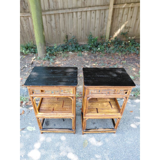 Striking pair of vintage spotted-bamboo side tables featuring black-finished rectangular tops, open geometric fretwork and...