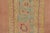Handwoven in wool, circa 1920–1940, this antique 2x10 Oushak runner rug features a narrow floral corridor design in faded...