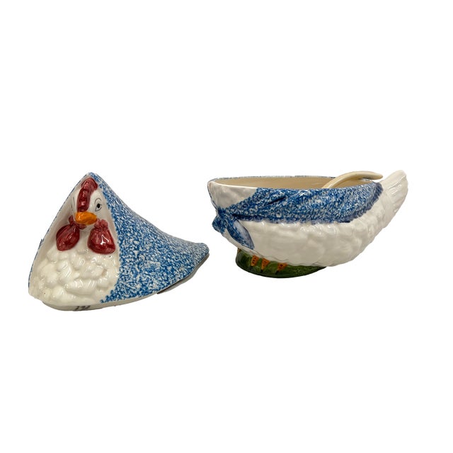 A vintage ceramic chicken-shaped soup tureen with a blue spongeware or stipple pattern "shawl" and base, most commonly...