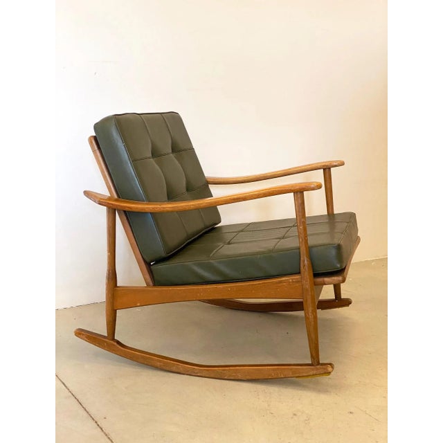 Rocking armchair in beech wood with green leather cushions. 1960s.