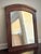 A handsome vintage arched mirror featuring a richly grained walnut finish frame with layered architectural molding and...