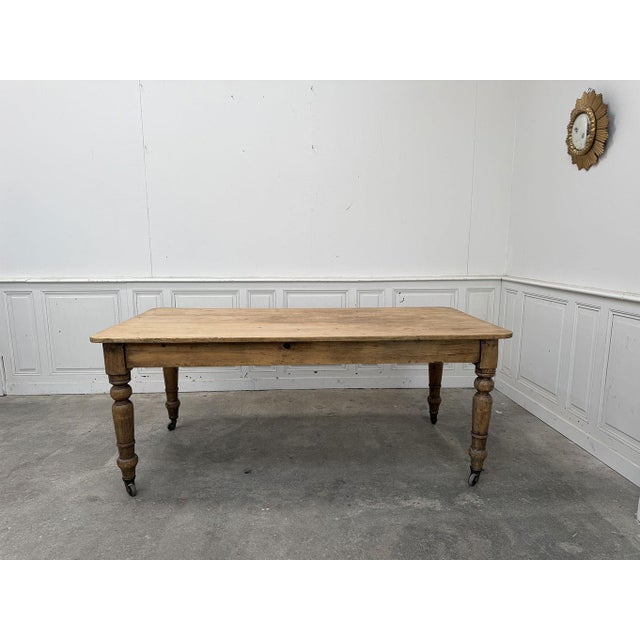 This vintage work table was likely used as a draper's or haberdashery table. Equipped with a brass wheeled frame...