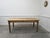 This vintage work table was likely used as a draper's or haberdashery table. Equipped with a brass wheeled frame...