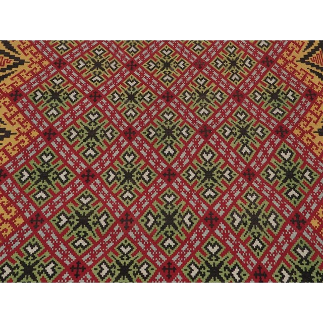 Handwoven in wool circa 1950-1960, this 10x12 vintage Kilim rug is believed to be a rare Balkan Kilim—an exciting new...