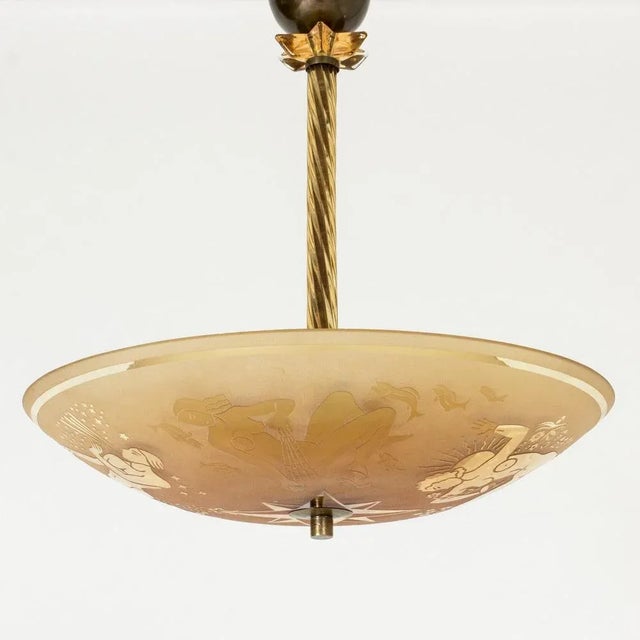 Stunning chandelier by Edward Hald, made from crystal glass. Beautiful amber color that creates a soft glow. Etched decor...