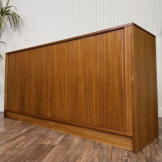 Vintage MCM Danish tambour door credenza or dresser by Hundevad in teak veneer, with a clean, low profile and a grain-...