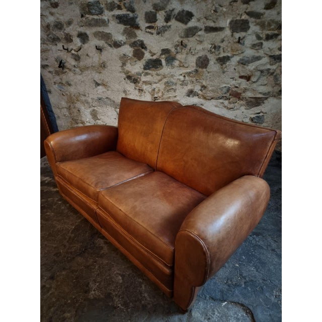 This vintage French moustache leather sofa was produced in France during the 1940s–1950s and represents the refined...
