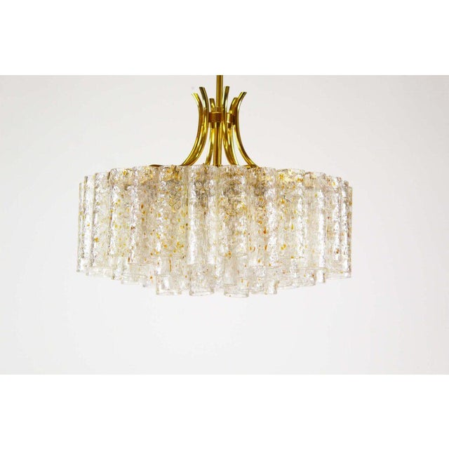 Large and impressive brass and glass chandelier by doria. Brass frame surrounded by glass tubes, decorated with gold...