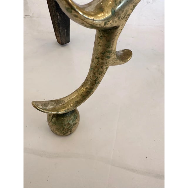 Classic shiny impressive pair of cast brass cannon ball andirons in the Chippendale style.