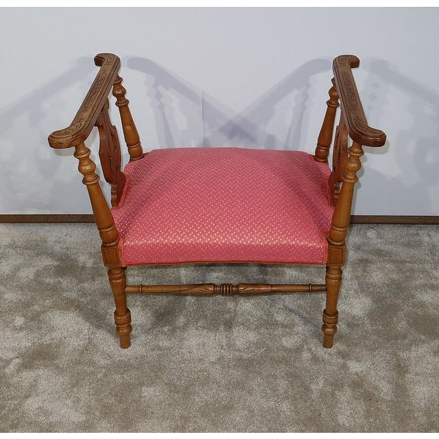 Charming massive walnut bench with refined lines, with openwork additions, composed on top of an element of wood carved...