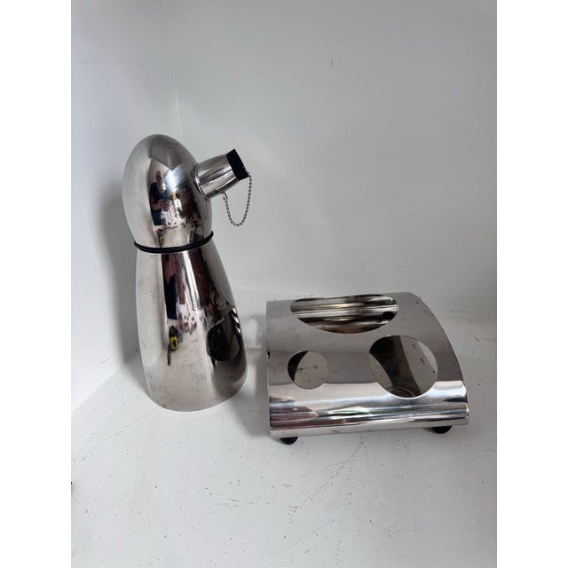 A silver cocktail shaker — penguin — with a rubber cork and chain and the base — both have the mark/signature on the...