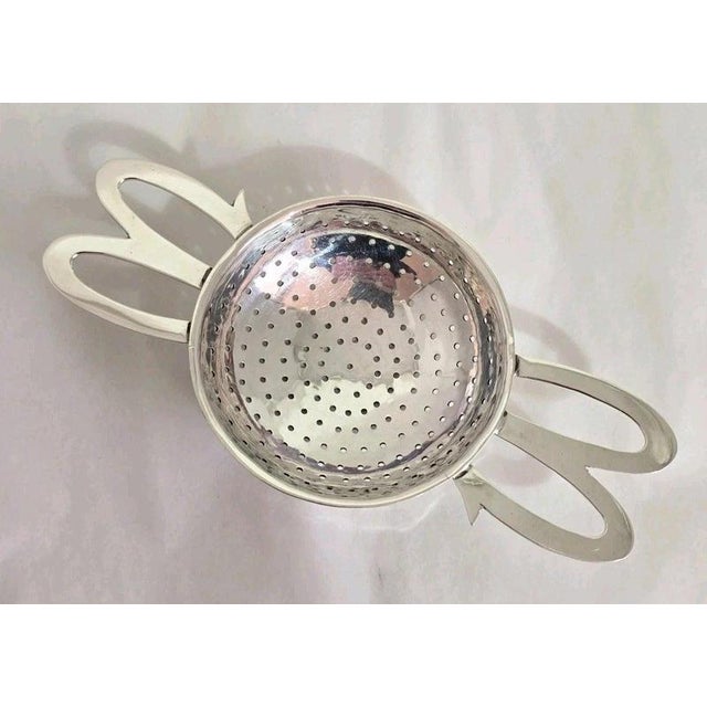 A george vi sterling silver loose tea strainer, hallmarked sheffield 1948. The strainer features a corded border...