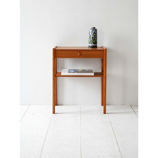 Teak bedside table with central drawer and low shelf. Simple line and slim structure. Vintage Scandinavian teak bedside...