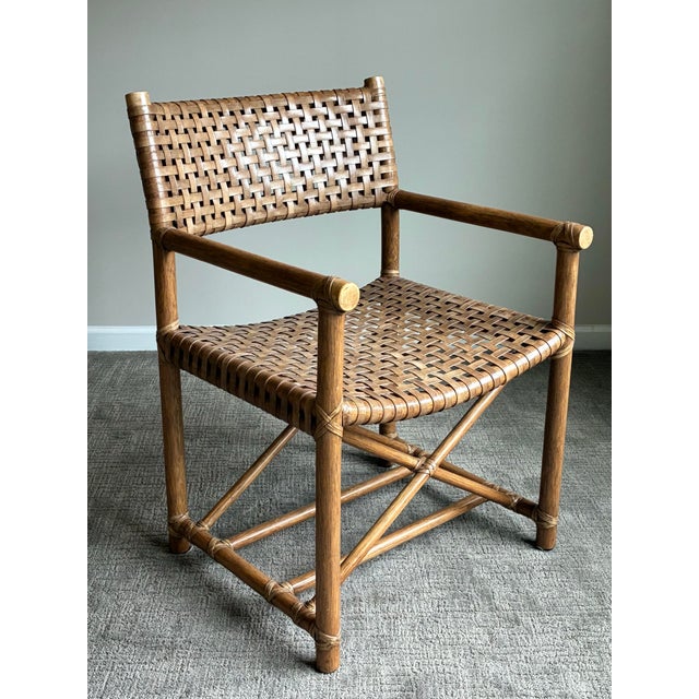 Handsome vintage coastal campaign-style armchair featuring a beautifully woven leather strap seat and back with faux...