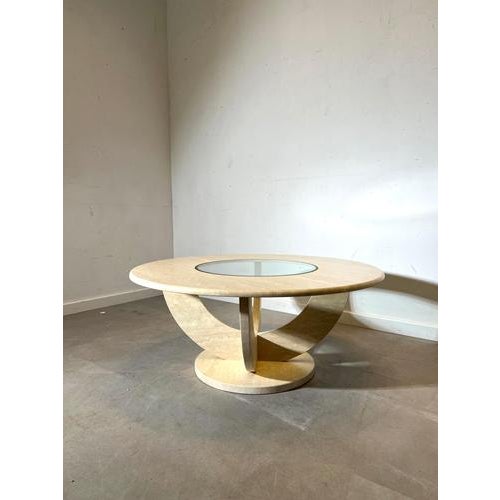 Elegant vintage coffee table in travertine with a striking sculptural base and inset glass centre. The round top, warm...