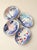 A set of four hand-painted blue-and-white ceramic bowls, each featuring a unique floral or botanical motif; the fresh blue...