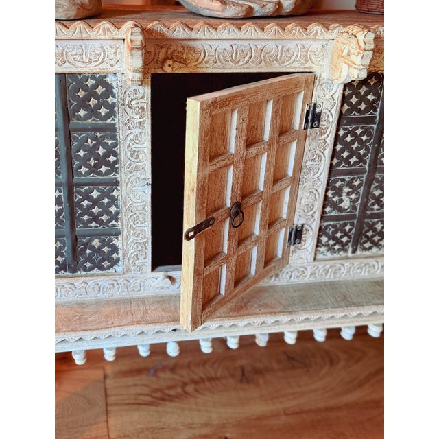 A characterful mid-to-late 20th-century Indian cabinet, richly hand-carved and finished in a beautifully aged whitewash....