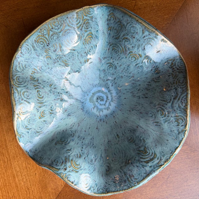 Pale blue studio pottery bowl from the 1970's. Interesting waved overall design with swirl glaze details. Maker's mark on...