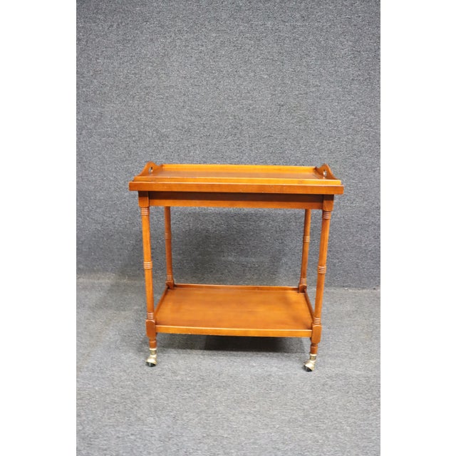 Mahogany tea cart with lift top, lower shelf and casters.
