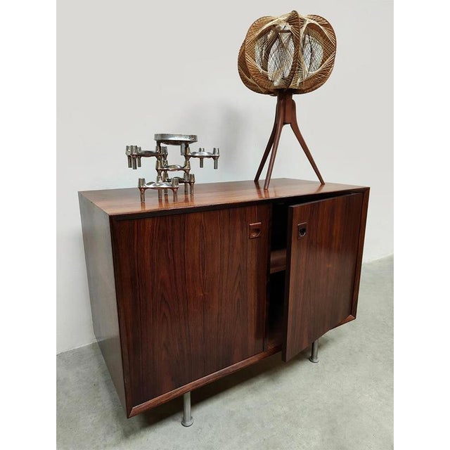 Less is more! A beautiful minimalist wooden cabinet with sleek chrome legs. Period: 1960. A nice detail are the beautiful...
