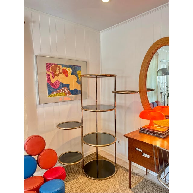 A vintage Milo Baughman style 7 tiered brass & smoked glass articulating etagere, circa 1970s. In very good original...