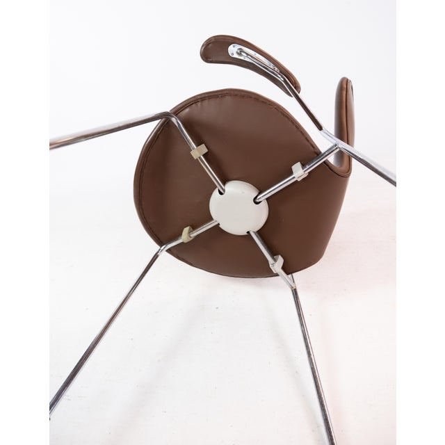 A set of seven chairs, model 3207, with arms in dark brown colored leather designed by Arne Jacobsen in 1955 and...