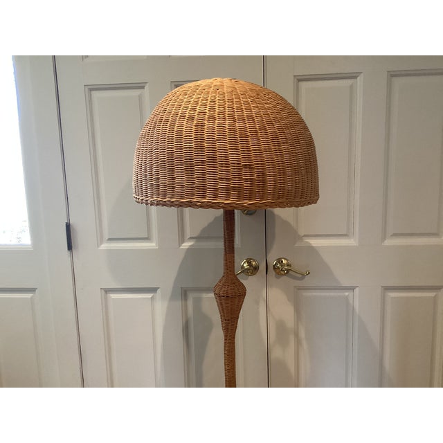 This vintage rattan floor lamp would look good in a living room or bedroom. The neutral color and material would be...