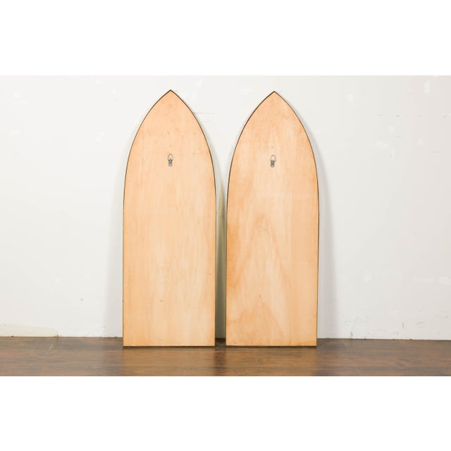 A pair of vintage Midcentury brass Gothic inspired mirrors from circa 1950 with broken arch silhouette and golden hue....