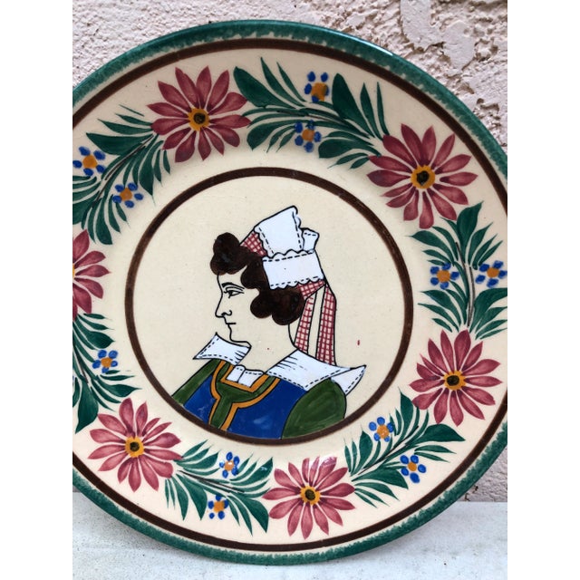 French faience plate Quimper, circa 1920 Border with flowers, representing a woman with a traditional Brittany cap.