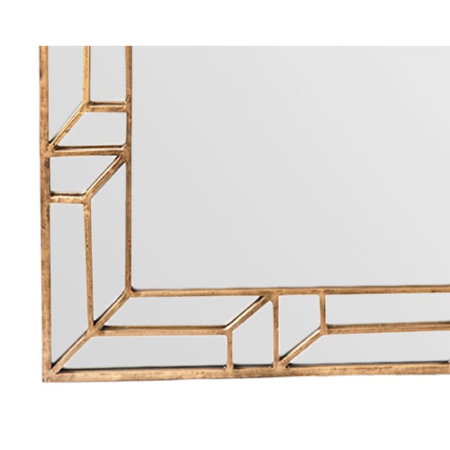 Crafted with a metal frame finished in hand-applied gold leaf, this striking mirror features a sophisticated geometric...