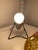 This vintage mid-century modern table lamp features a compact tripod form with an adjustable metal body mounted on a black...