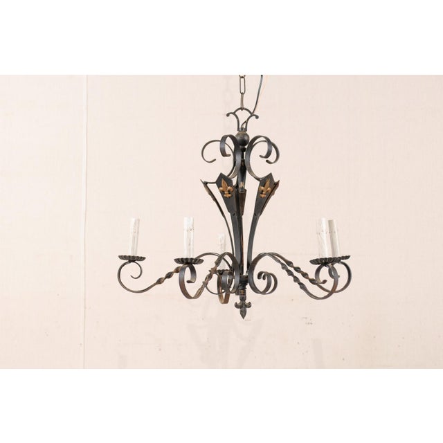 A French five-light iron chandelier. This French vintage mid 20th century chandelier features five s-scrolled and twisted...