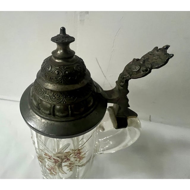 Covered beer mug in enameled glass The handle and lid are made of pewter The glass has an enameled floral design Good...