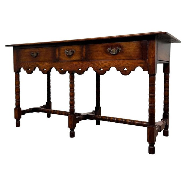 A handsome and well-crafted early 20th-century English oak dresser base, designed in the Jacobean style and displaying the...