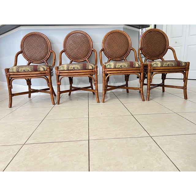 Set of Four Vintage Bamboo & Rattan Cane Back dining chairs. McGuire Style Dining Chairs. They feature a distinct oval-...