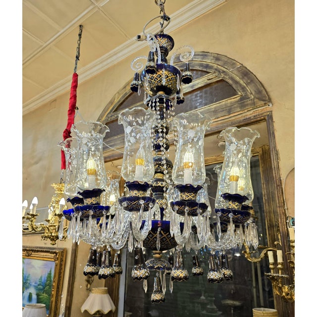 This exquisite chandelier features a refined blue and white color palette, beautifully enhanced with hand-applied gold...
