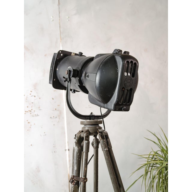 A strand electric patt 23n follow spot from the 1960s in its original black paint, on a height-adjustable bundeswehr field...