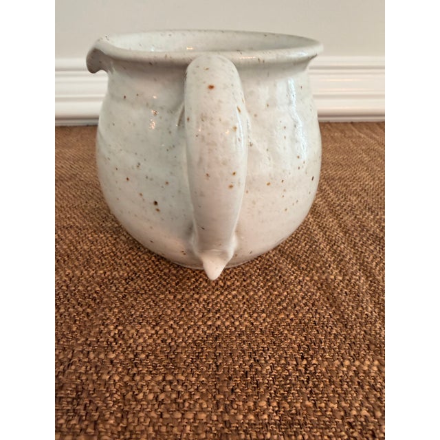 Charming vintage Portuguese stoneware pitcher with creamy speckled glaze, rounded hand-crafted form, and sculptural pour...