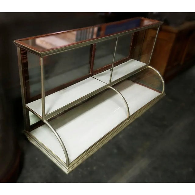 Vintage two tiered showcase with rounded glass on bottom and sliding mirrored doors at back