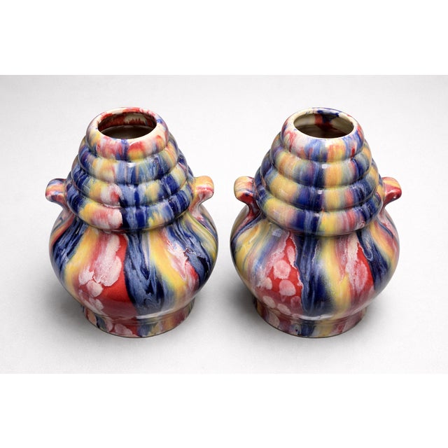 This pair of ceramic vases by Elgé powerfully illustrates the expressive and colorful aesthetic of mid-20th-century French...