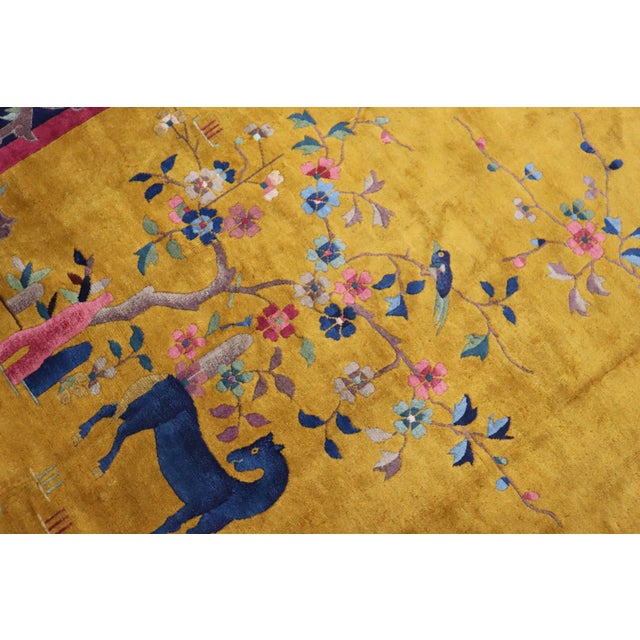 A Chinese Art Deco Nichols rug with a pictorial animal design on a goldenrod field surrounded by a pink and plum floral...